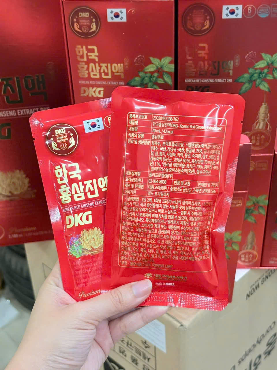 Gói nước ép hồng sâm 6 năm tuổi Daedong với hoa chuông và đông trùng hạ thảo đặt cạnh ly nước chuẩn bị sử dụng